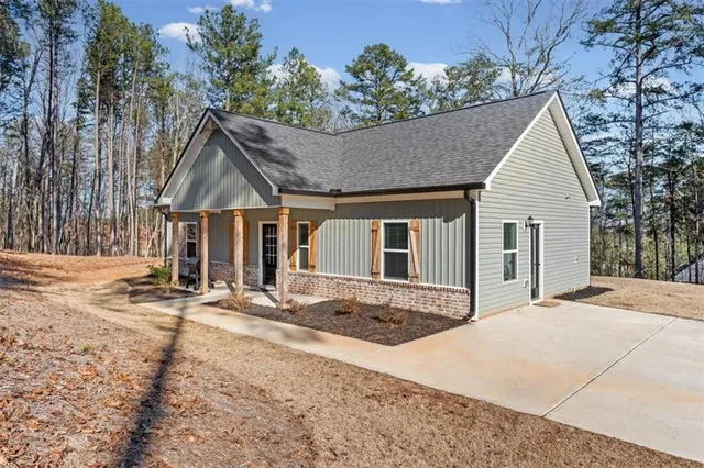 a view of a house with a yard and wooden fence