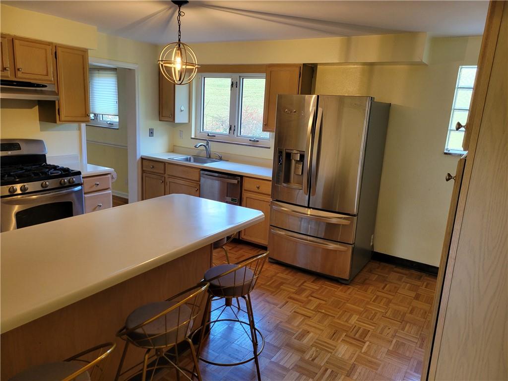 1260 Fox Chapel Road Pittsburgh, PA 15238 - Photo 11 of 29 a kitchen with stainless steel appliances a refrigerator a stove a sink a dining table and chairs