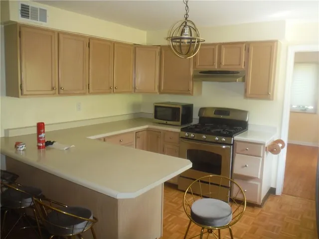 a kitchen with a sink a stove and chairs