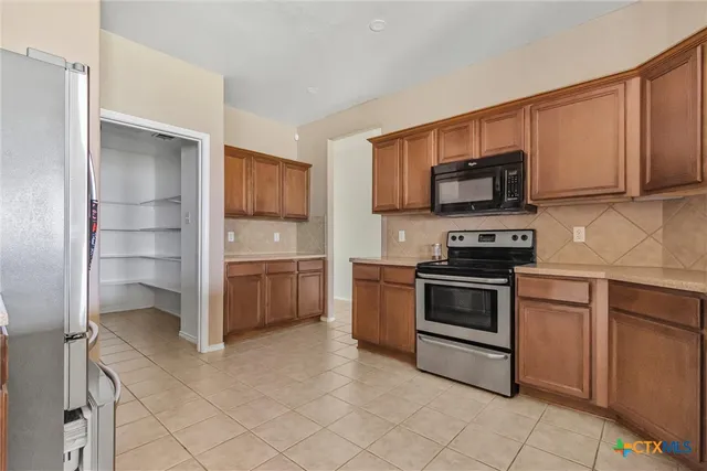 a kitchen with stainless steel appliances a stove sink and microwave