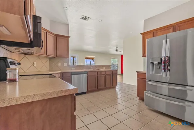 a kitchen with stainless steel appliances granite countertop a sink stove and cabinets