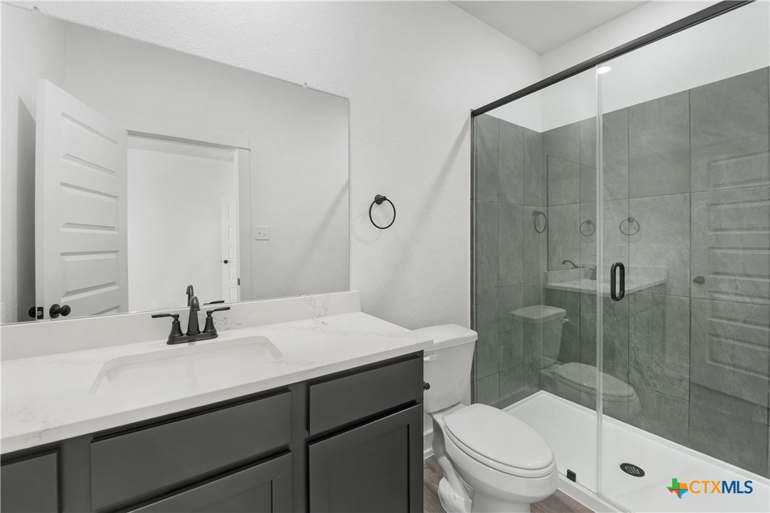 1807 Bear Grass Rdg Road Temple, TX 76501 - Photo 13 of 16 a bathroom with a sink a toilet a mirror and shower