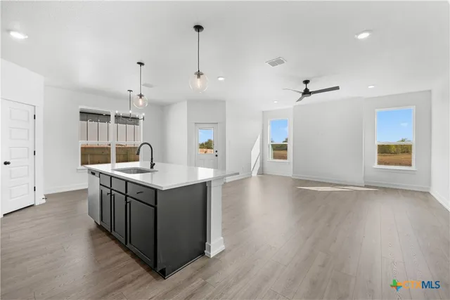 a view of a kitchen with a sink and dishwasher a refrigerator with wooden floor