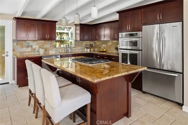 a kitchen with stainless steel appliances granite countertop wooden cabinets stove top oven and sink