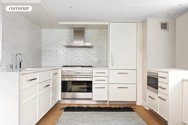 a large white kitchen with cabinets