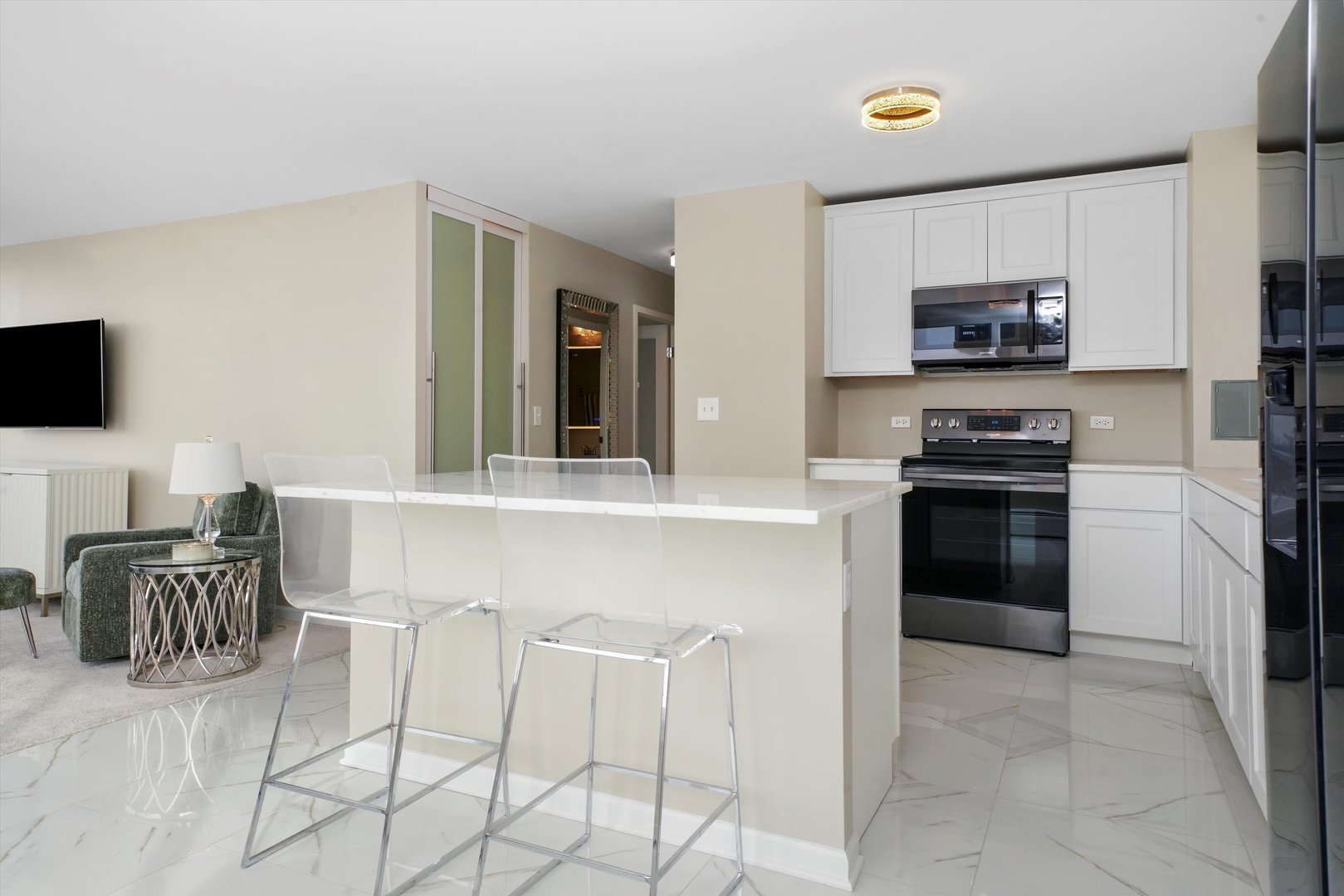 6171 North Sheridan Road, Unit 1401 Chicago, IL 60660 - Photo 6 of 29 a kitchen with granite countertop a stove top oven microwave and dining table