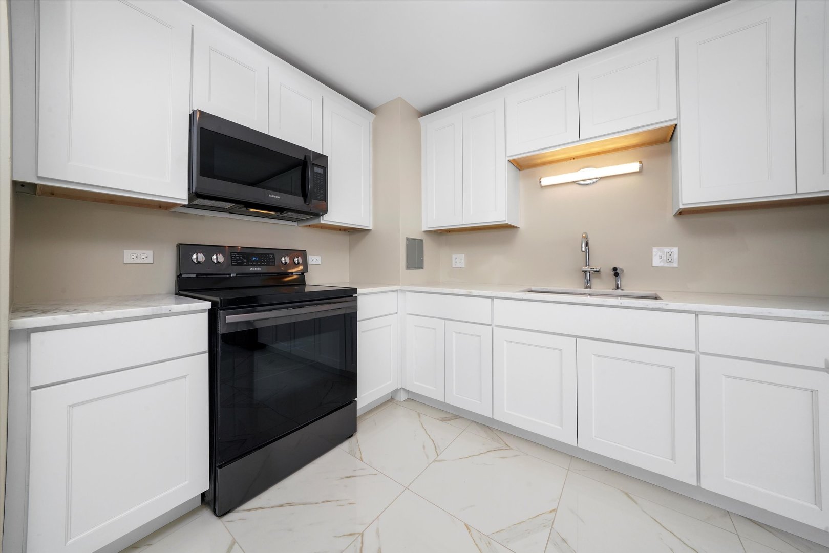 6171 North Sheridan Road, Unit 1401 Chicago, IL 60660 - Photo 7 of 29 a kitchen with white cabinets appliances and a sink