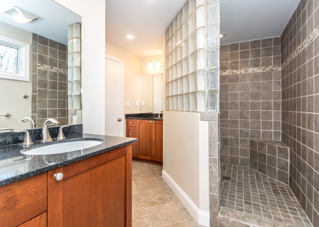 60 Pershing Road Needham, MA 02494 - Photo 15 of 30 a bathroom with a granite countertop sink a mirror and shower