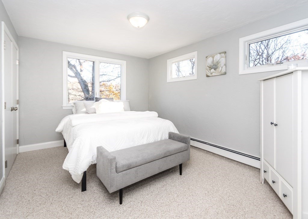 60 Pershing Road Needham, MA 02494 - Photo 19 of 30 a bed sitting in a bedroom next to a window