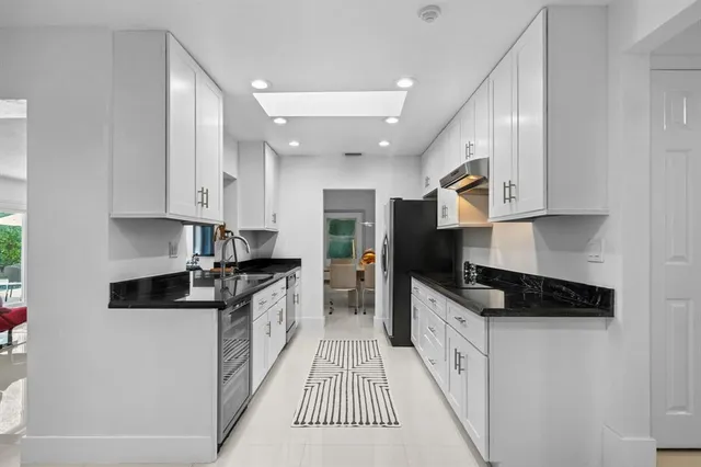 a large kitchen with stainless steel appliances granite countertop a stove and a sink