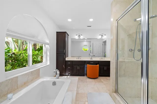 a bathroom with a tub a sink and window