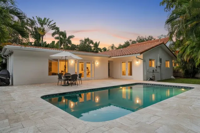 a view of a house with swimming pool and sitting area