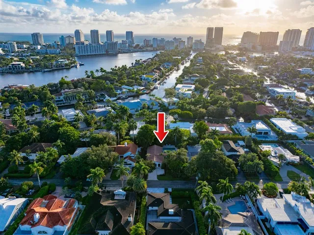 an aerial view of city and lake with trees all around