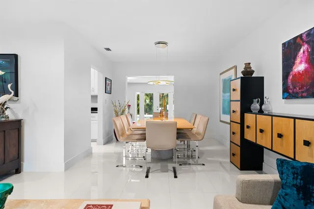 a dining room with furniture a mirror and a flat screen tv