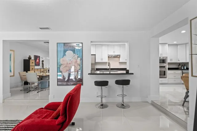 a dining room with stainless steel appliances kitchen island granite countertop a table and chairs