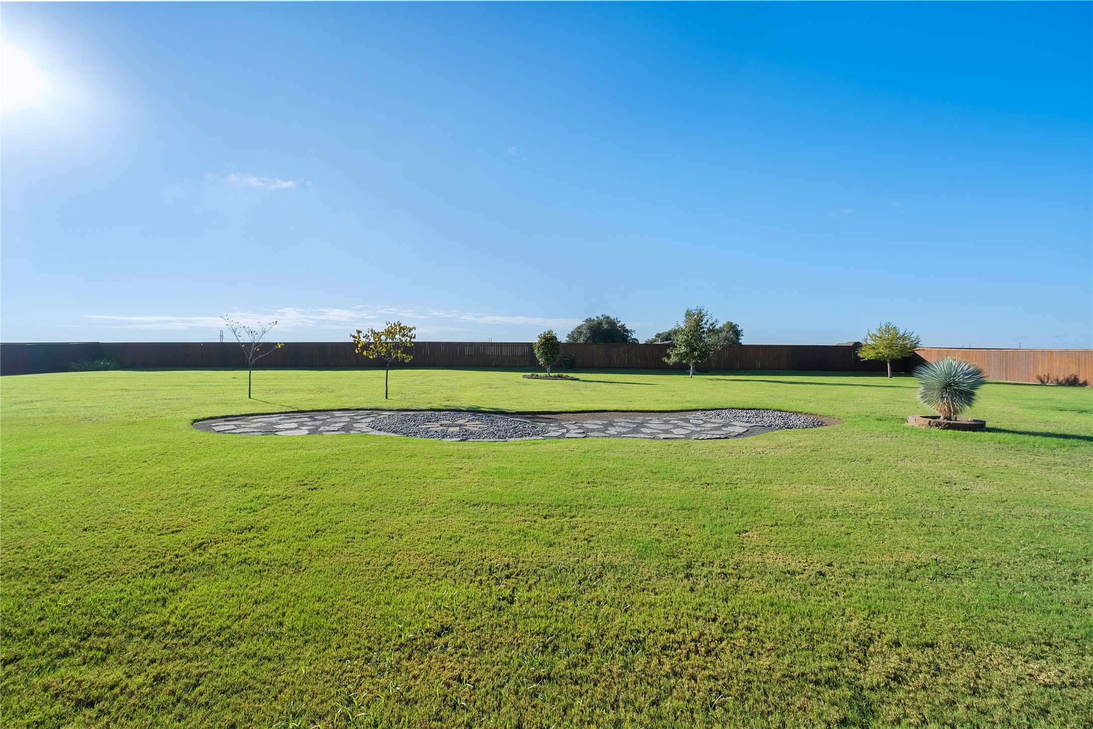 955 Inka Road Salado, TX 76571 - Photo 29 of 39 An expansive green lawn is enclosed by a privacy fence under wide blue skies.
