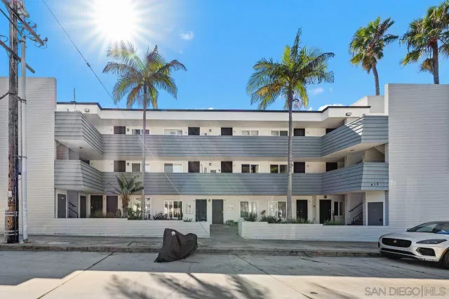 a front view of a building with palm trees