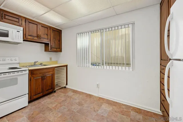 a view of kitchen with refrigerator and cabinet