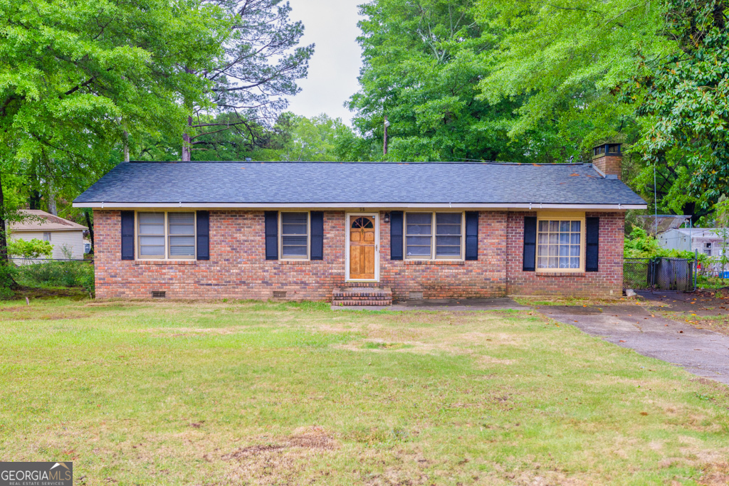 a front view of a house with a garden and tree