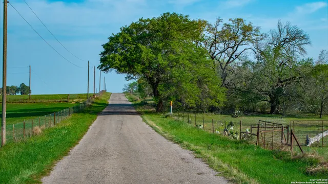 a view of green field with wooden fence