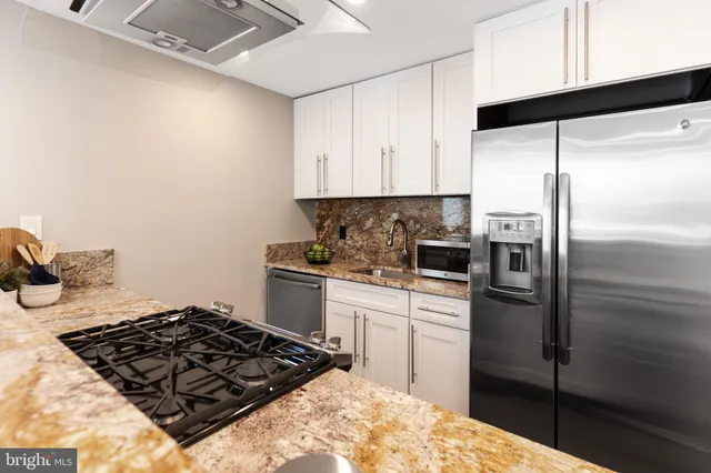 a kitchen with a refrigerator stove and cabinets