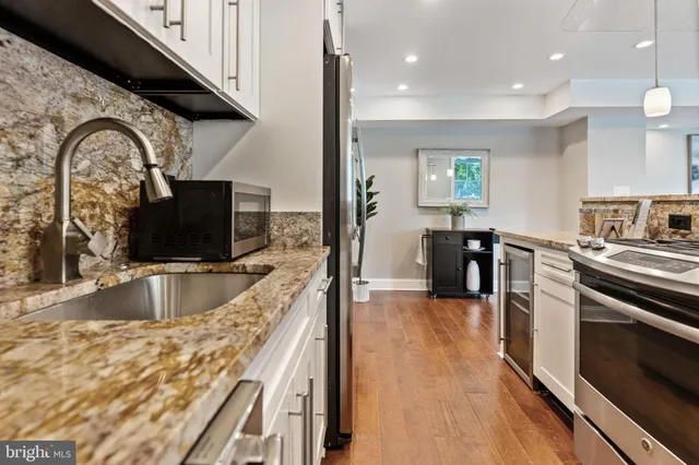 a kitchen with stainless steel appliances granite countertop a sink and a stove
