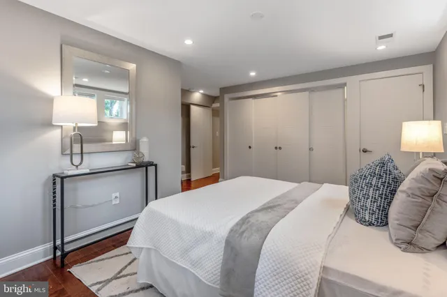 a bedroom with a bed and a mirror on dresser