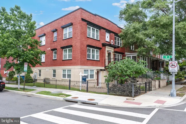 a view of a brick building next to a yard