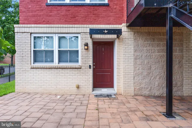 a front view of a building with a brick wall and a window
