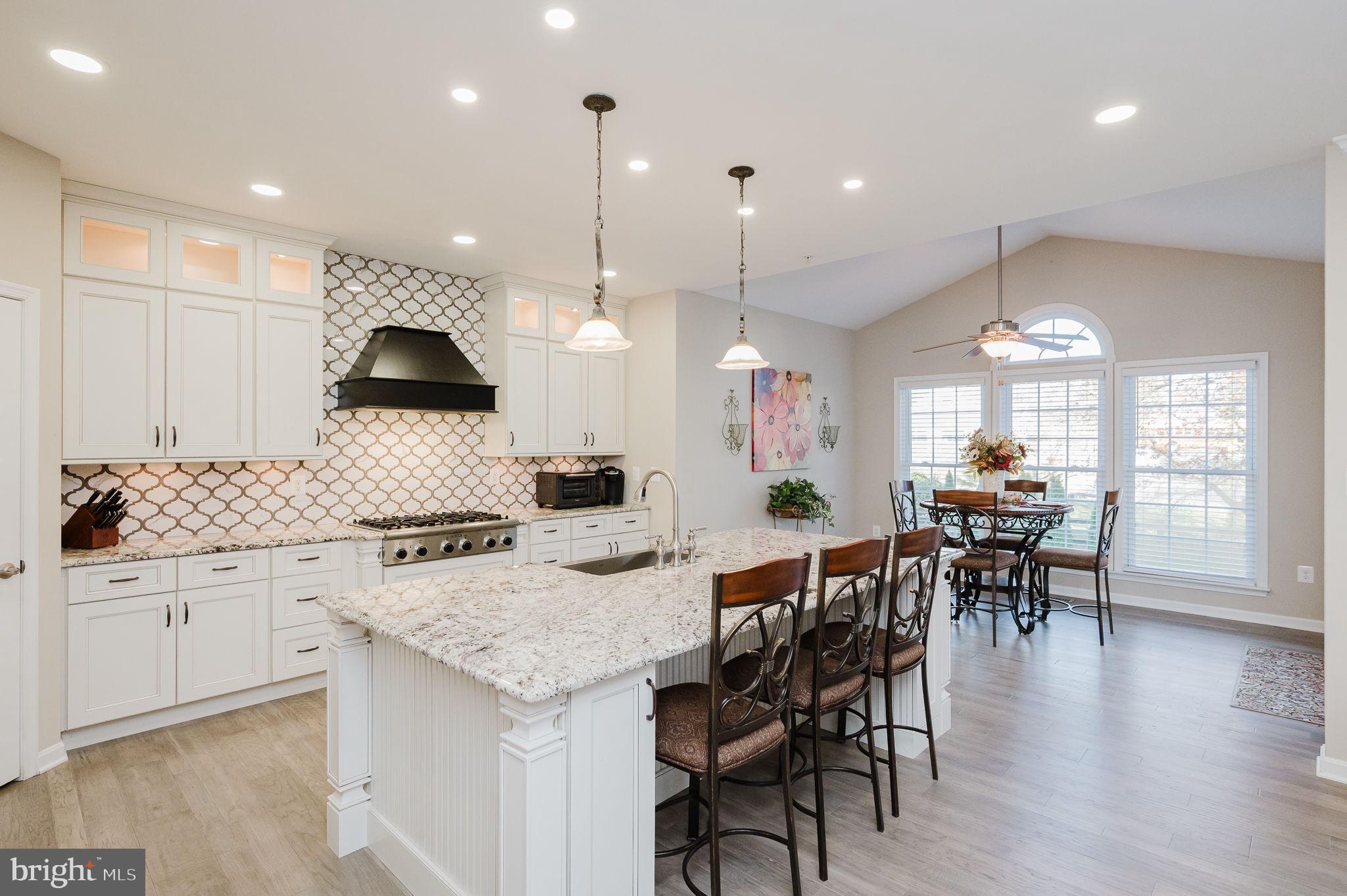 823 Bridle Path Bel Air, MD 21014 - Photo 18 of 66 a kitchen with stainless steel appliances granite countertop a stove a sink a kitchen island with chairs and wooden floor