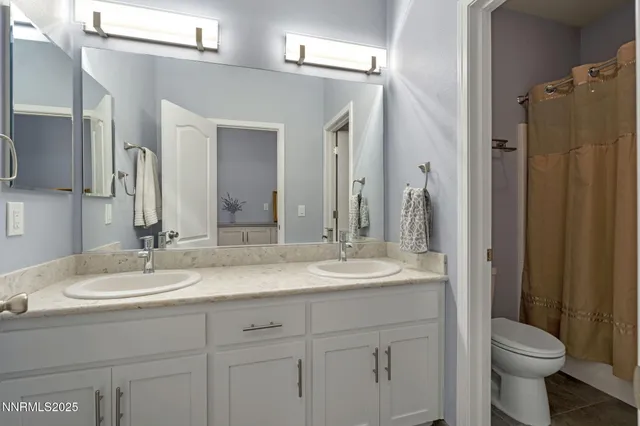 a bathroom with a double vanity sink toilet and shower