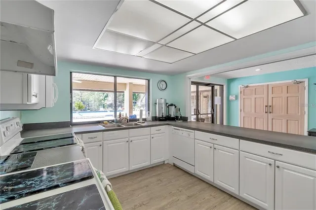 a large white kitchen with a large window