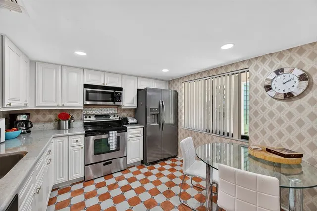 a kitchen with stainless steel appliances granite countertop a stove a sink and a refrigerator
