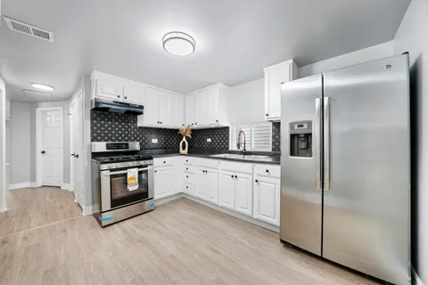 a kitchen with stainless steel appliances a refrigerator sink and microwave