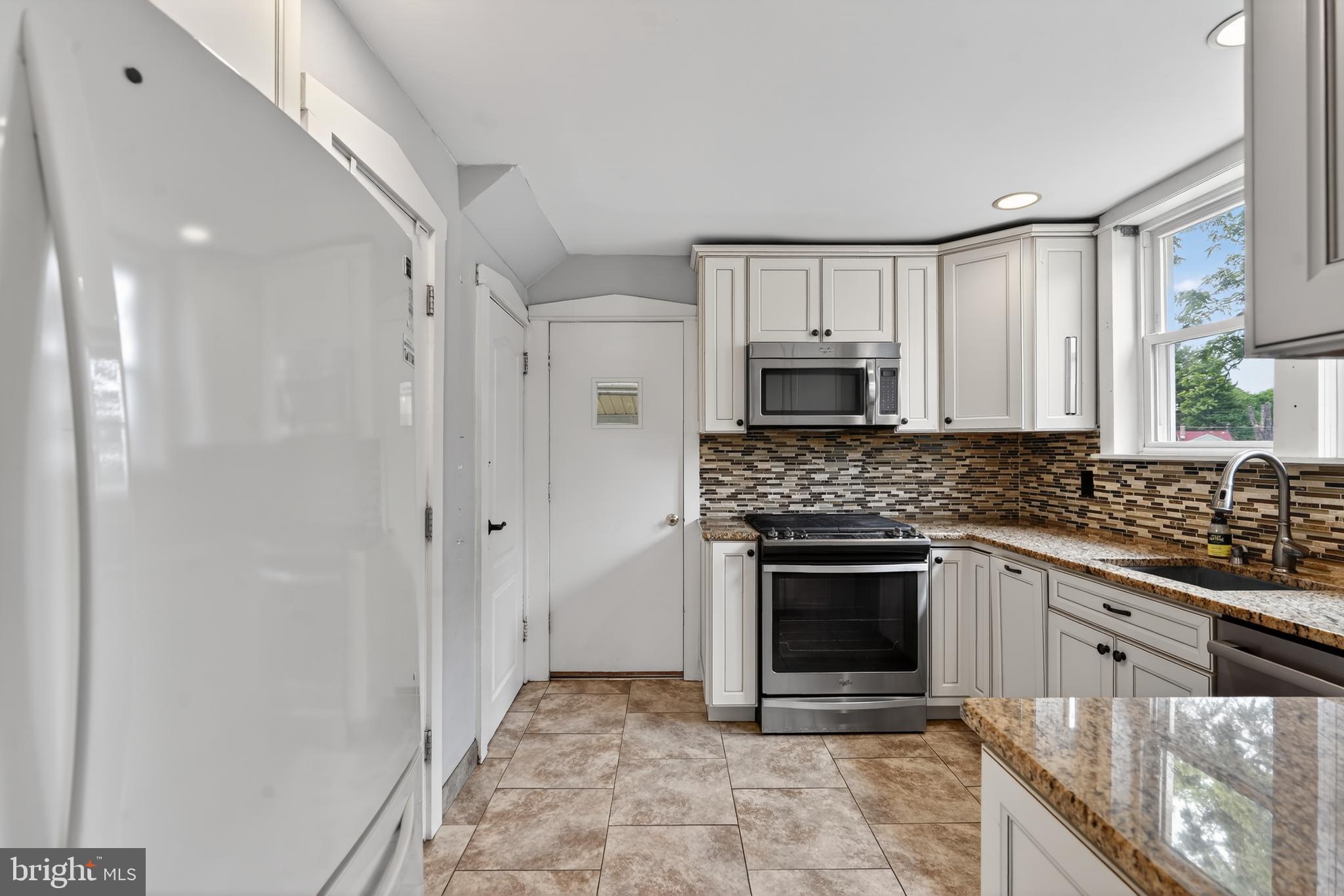 106 Ford Street Voorhees, NJ 08043 - Photo 13 of 36 a kitchen with granite countertop a stove sink and cabinets