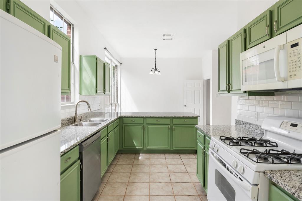 559 Raintree Circle Coppell, TX 75019 - Photo 11 of 40 U-shaped kitchen featuring green cabinetry, granite-finish countertops, and a white subway tile backsplash