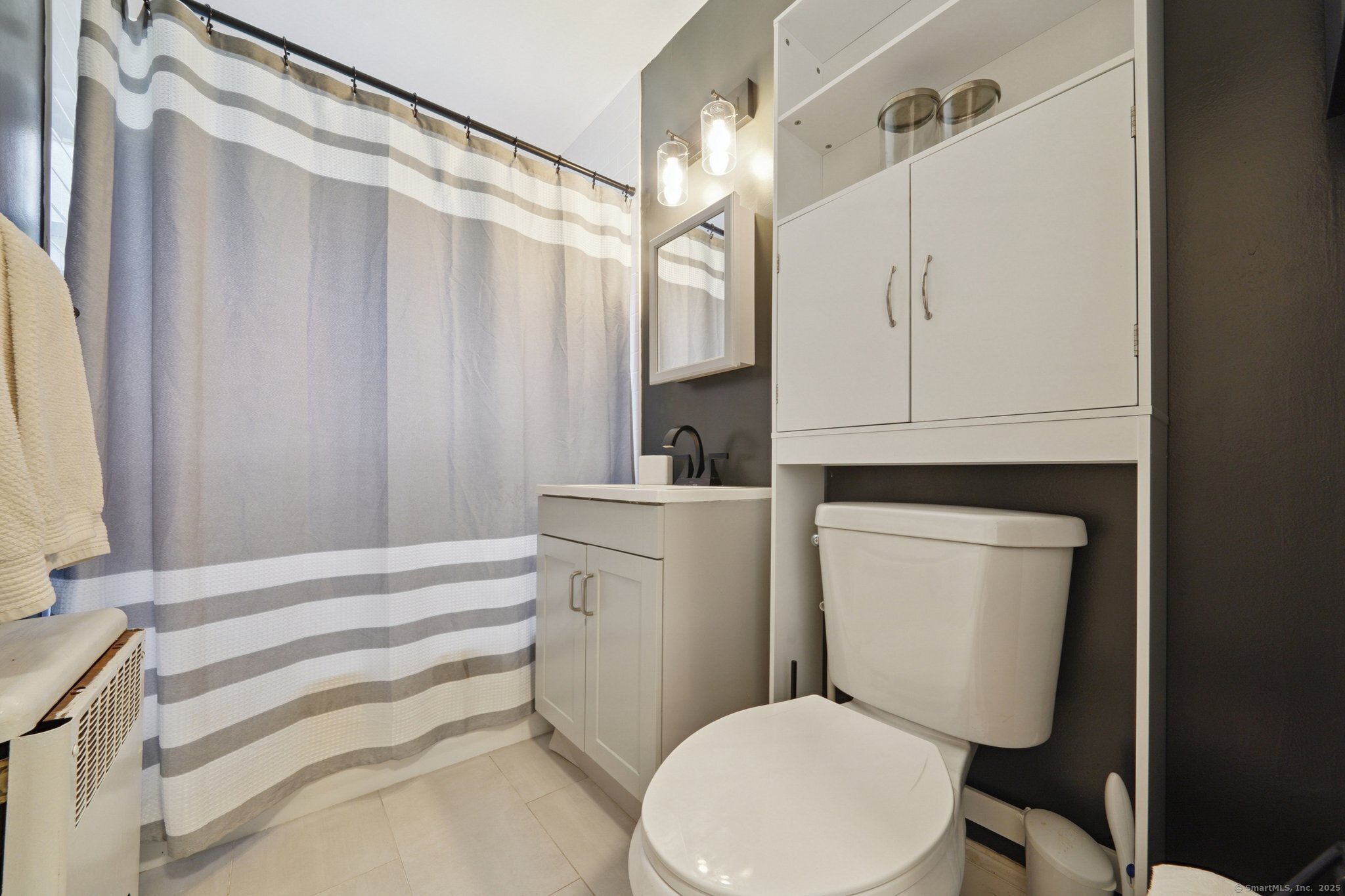 108 Strawberry Hill Avenue, Unit 1 Stamford, CT 06902 - Photo 11 of 20 a white toilet sitting next to a bathroom sink