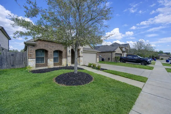 a front view of a house with a garden and trees