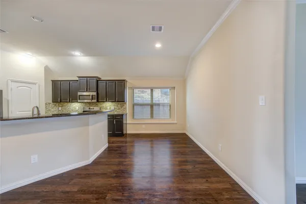 a view of a kitchen with a sink and wooden floor