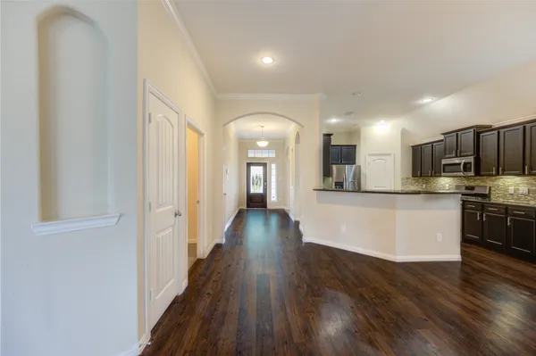 a large kitchen with stainless steel appliances wooden floors and wooden cabinets