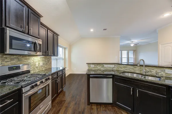 a kitchen with stainless steel appliances granite countertop a sink stove and refrigerator