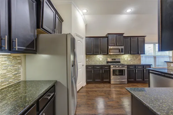 a kitchen with stainless steel appliances granite countertop a sink stove and refrigerator