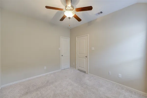an empty room with a window and a fan