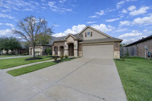 a view of an empty room with wooden floor and a ceiling fan