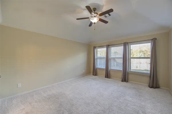 an empty room with closet and a ceiling fan