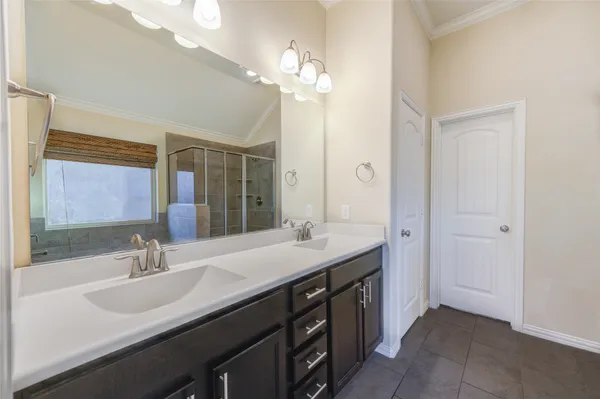 a bathroom with a double vanity sink a large mirror a bathtub and shower