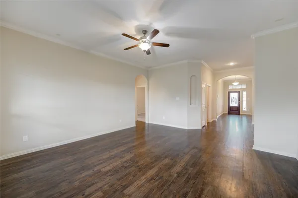 a view of a big room with wooden floor and a ceiling fan