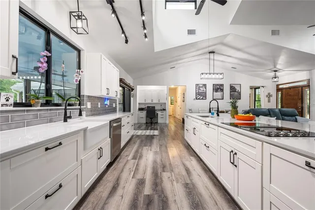 a spacious bathroom with a double vanity sink a large mirror a toilet and a window