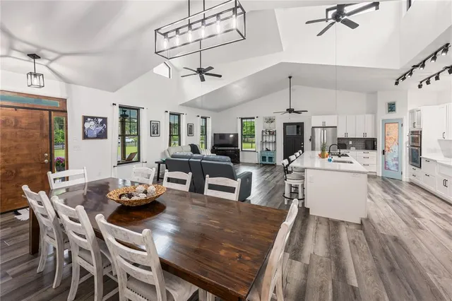 a bedroom with a large bed and a chandelier fan