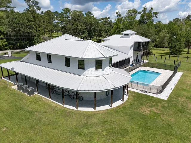 a living room with furniture kitchen view and a wooden floor